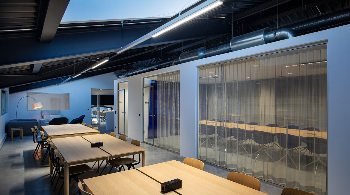 Arbeitsbereiche im Neubau ergänzen die historische Halle um Räume für konzentriertes Arbeiten, Projektarbeit und Meetings.