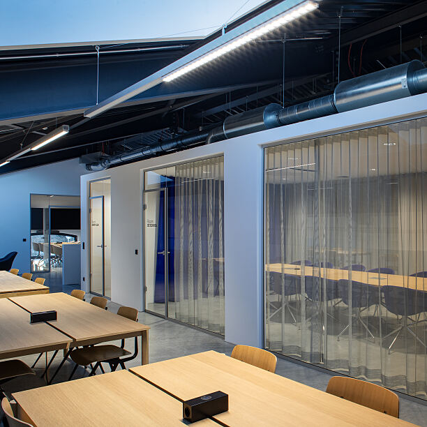 Arbeitsbereiche im Neubau ergänzen die historische Halle um Räume für konzentriertes Arbeiten, Projektarbeit und Meetings.