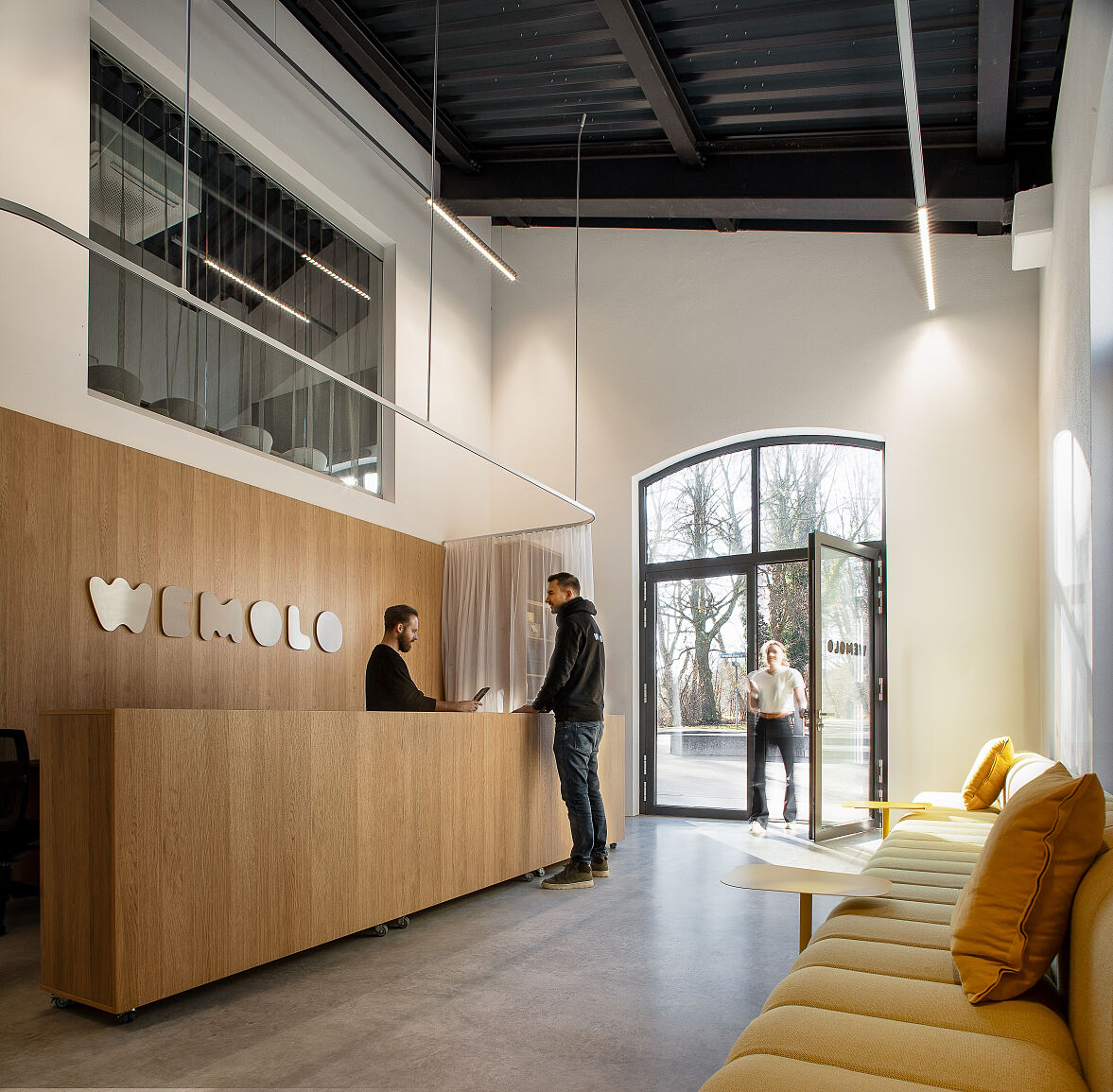 Ankommen im neuen Wemolo-Standort in München-Thalkirchen: Der Empfangsbereich in der denkmalgeschützten Triebwagenhalle dient als zentrale Schnittstelle für Mitarbeitende und Besucher.