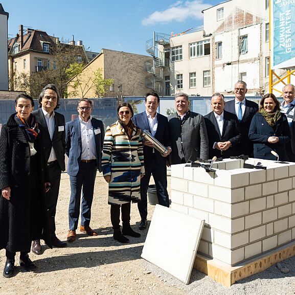 Personen auf dem Foto von links nach rechts: Rita Ahlers, Partnerin und Architektin bei Hilmer Satller Architekten; Peter G. Neumann, Gründer und Gesellschaftler der Rock Capital Group; Andreas Wißmeier, Geschäftsführer der Rock Capital Group; Stadtbaurätin Prof. Dr. (Univ. Florenz) Elisabeth Merk; Christian Lealahabumrung, Grüner und Gesellschafter der Rock Capital Group; Christian Bernreiter, Staatsminister für Wohnen, Bau und Verkehr; Dr. Christian Scharpf, Referent für Arbeit und Wirtschaft; Dr. Constantin H. Alsheimer, Vorstandsvorsitzender der THÜGA; Verena Dietl, Dritte Bürgermeisterin von München; Dr. Matthias Cord. 