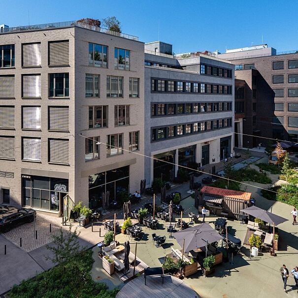 Mixed Use im Münchner Osten: Rund um den zentralen Quartiersplatz der Macherei München liegen sechs Gebäude mit mehr als 75.000 Quadratmetern Mietfläche für Büro, Gastronomie, Handel, Hotel und Fitness. Seit Juli 2026 ergänzt eine Kita den Nutzungsmix.