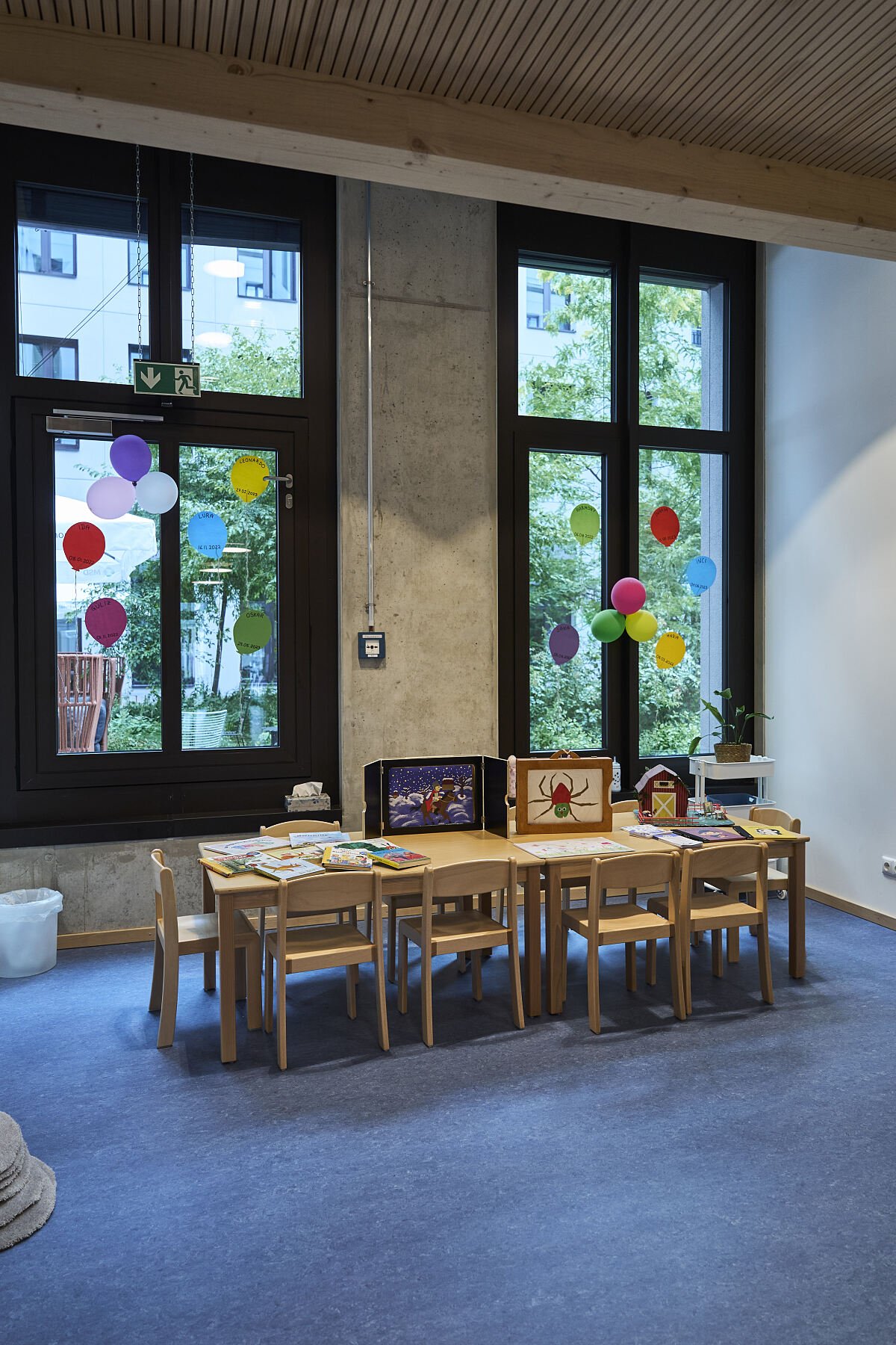 Große Fenster bringen viel Tageslicht in einen der Gruppenräume. Der lange Tisch und die freien Bodenflächen lassen sich je nach Tagesablauf flexibel nutzen.