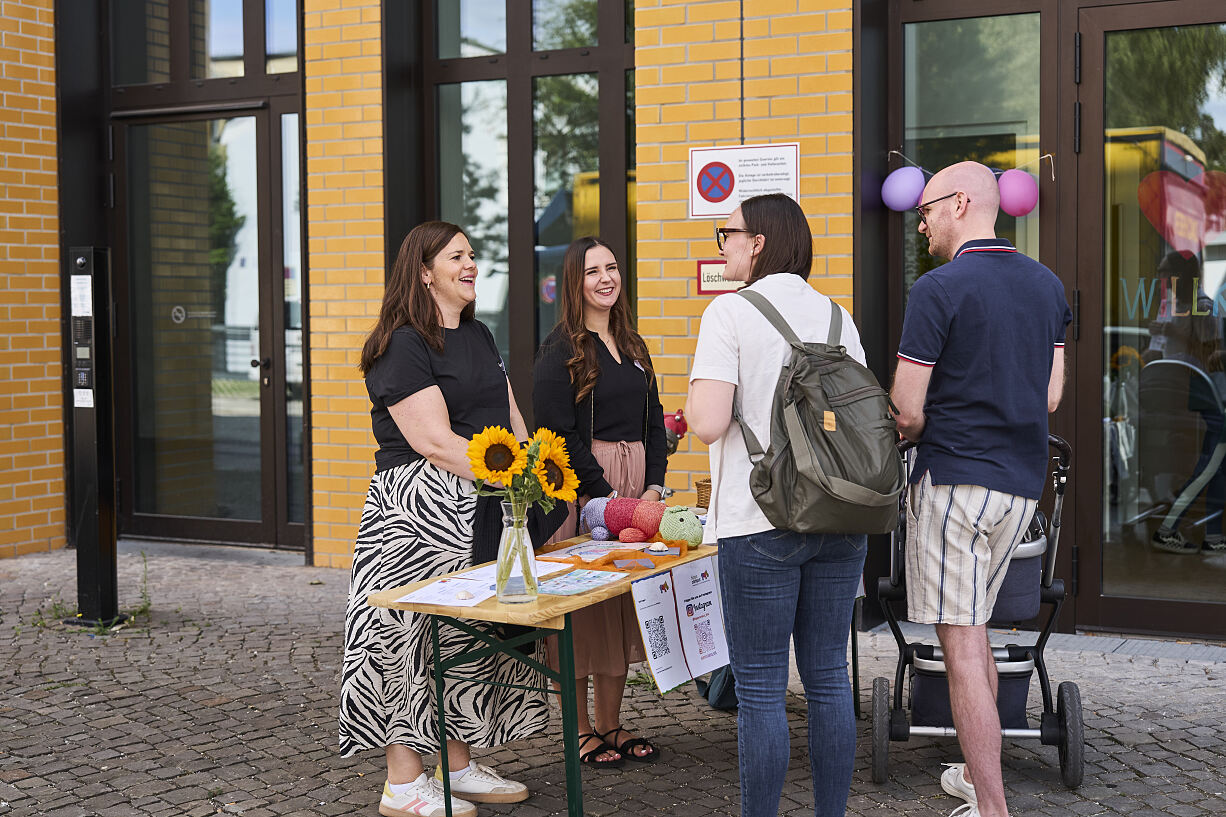 Informationen und Materialien für die Mitmachangebote: Ein Programmtisch beim Familienfest zur Eröffnung der neuen Kita.