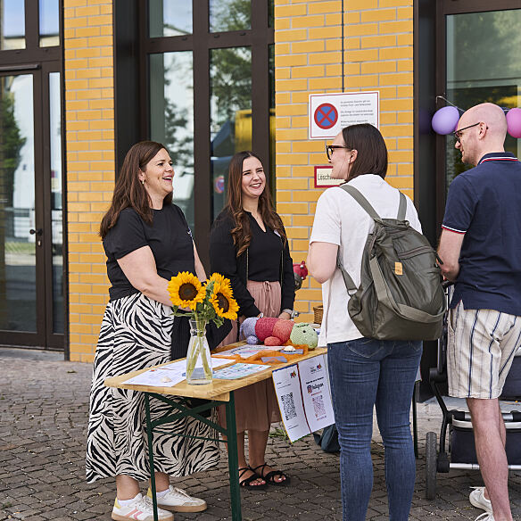 Informationen und Materialien für die Mitmachangebote: Ein Programmtisch beim Familienfest zur Eröffnung der neuen Kita.