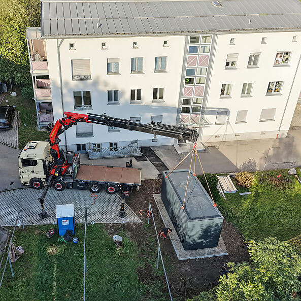 Anlieferung eines Wärmepumpen-Cubes in der Wohnanlage in Kempten. 