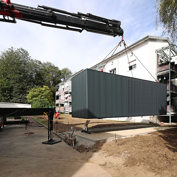 Absetzen eines betriebsbereiten Wärmepumpen-Cubes in Kempten. 