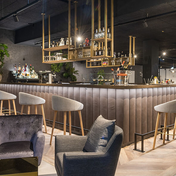 Eine hochwertige Bar mit gemütlichem Lounge-Bereich lädt zu inoffiziellen Gesprächen und After-Work Drinks ein.