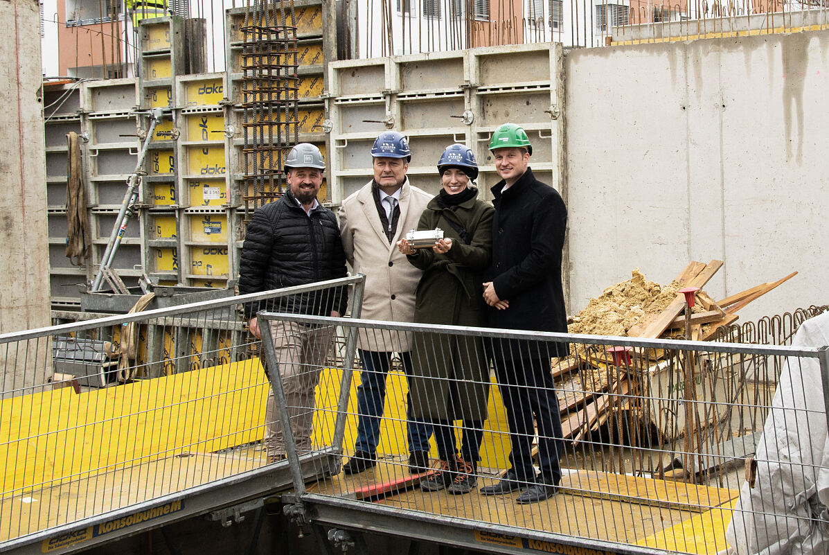 Bauverantwortliche mit Zeitkapsel, bevor sie in das Fundament gelegt wurde