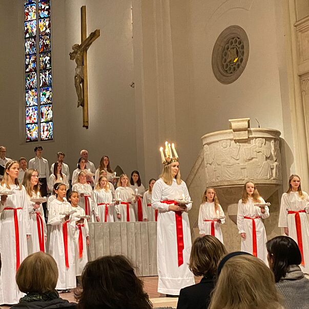 Das Ensemble beim Luciafest 2022 in der St. Matthäus-Kirche, mit weißen Gewändern und Lichterkronen.