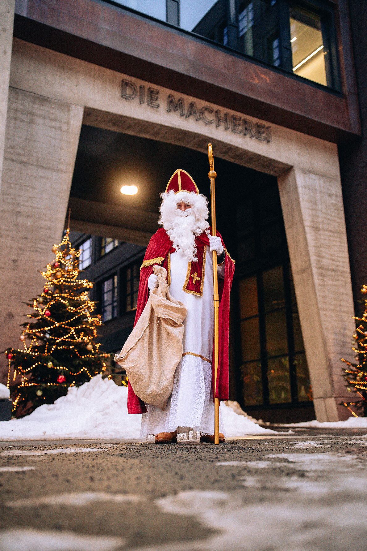 Der Nikolaus vor dem markanten Eingang der Macherei München – Teil des Familienprogramms der WeihnachtsMacherei 2025.
